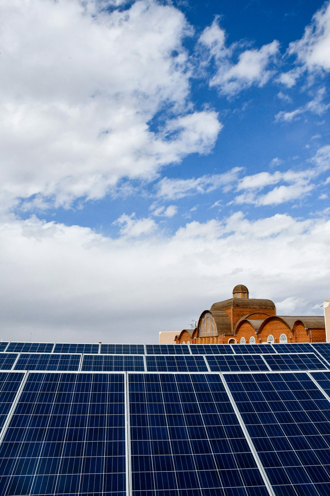 a-large-building-with-a-lot-of-solar-panels-on-top-of-it.jpg a large building with a lot of solar panels on top of it